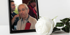 A framed photo of Nick Sion with a white rose in front