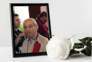 [:en]A framed photo of Nick Sion with a white rose in front[:]