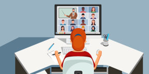 A student sits at a desk, watching a webinar