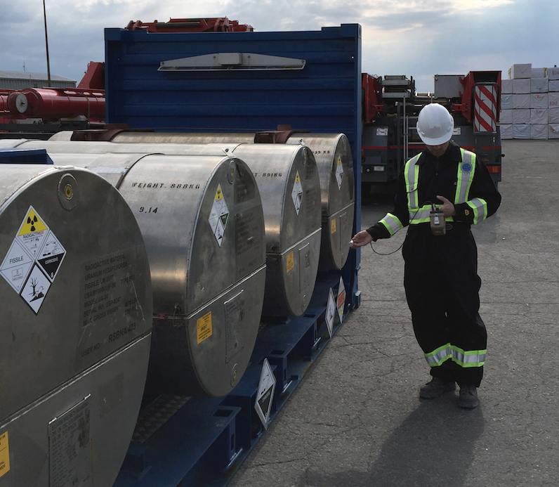 health physicist surveying a UN2977 package at a port