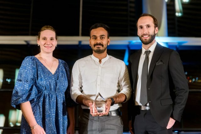 Leah Shuparski-Miller (left) and Matthew Bernacci (right) present the Anthony J. MacKay trophy to Felix Mathew (centre)