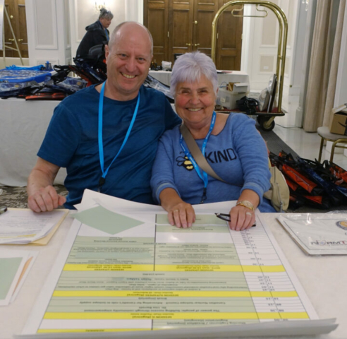 Thanks to our Halifax conference co-chairs, Gary Wilson and Pauline Jones! Gary Wilson (left) and Pauline Jones (right) sitting at a table in front of a conference schedule