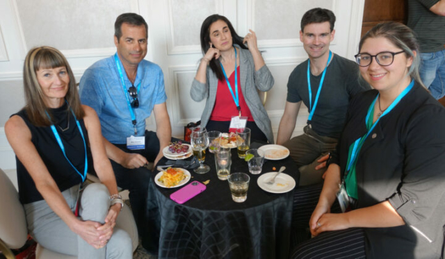 From left to right: Lorraine Manson, Mike Delorme, Paz Anrea Soriano, Bryan McIntosh, and Mackenzie Tigwell. Five people sitting at a reception table with food and drinks.