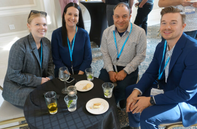 From left to right: Rachel Thompson, Jill Robertson, Ali Shoustarian, and Bryce Gillman. Four people sitting at a reception table with food and drinks.