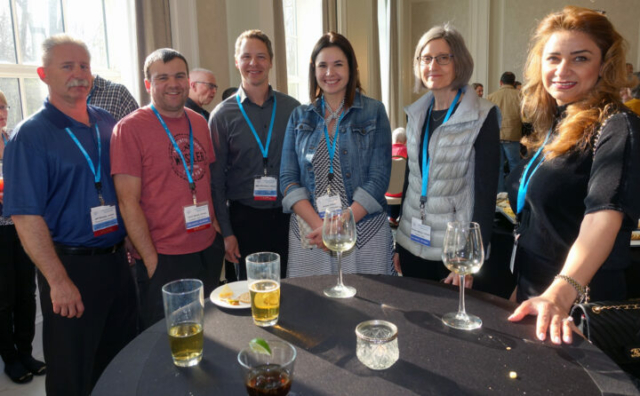 From left to right: Jeff Dovyak, Darin Street, Mike Stoicescu, Andrea Albert, Debbie Frattinger, and Mojgan Soleimani. Six people standing in a row behind a reception table. Crowd behind them.