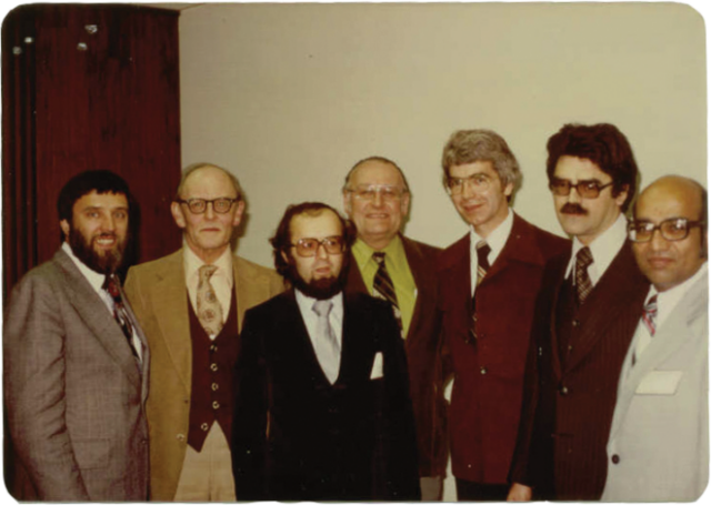 CRPA’s first board of directors in April 1979. Left to right: M. W. Greene, G. Cowper, M. Deschamps, A. Marko, R. Osborne, R. DesRochers, R. Chatterjee (absent D. Watson). A colour photos of a row of 7 men in suits