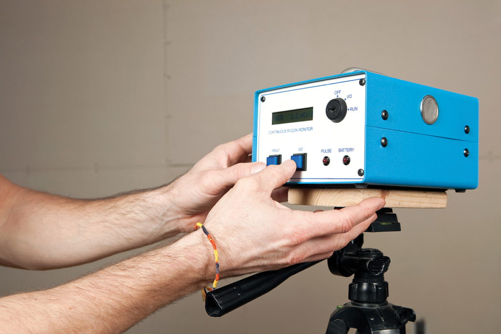 A pair of hands holding a blue box with dials and knobs