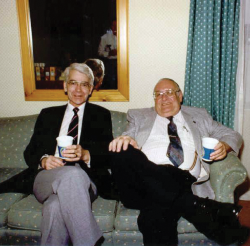 Richard Osborne and Art Marko at the CRPA conference in St. John, NB, in 1990. Two older men in suits sit side-by-side on a green couch.