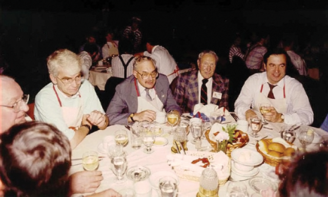 Richard Osborne, Allan Sourkes, and A. J. MacKay at the CRPA conference in St. John, NB, in 1990. A group od people are sitting around a table at a banquet. You can see other tables of people in the background